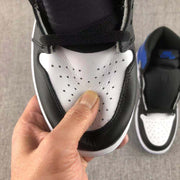 Close-up of the perforated white toe box and surrounding black overlay, with stitching and texture visible.