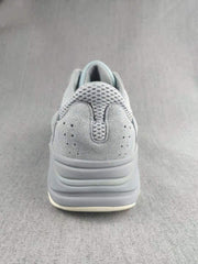 Rear view showing the padded heel, perforated upper panel, layered gray sole, and light outsole edge.