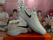 Pair of white Nike sneakers with black Swoosh logos displayed on an orange shoebox.