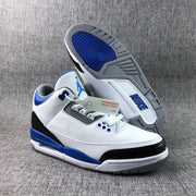 Three-quarter view of the sneaker with the outsole visible, showing blue, gray, white, and black sections.