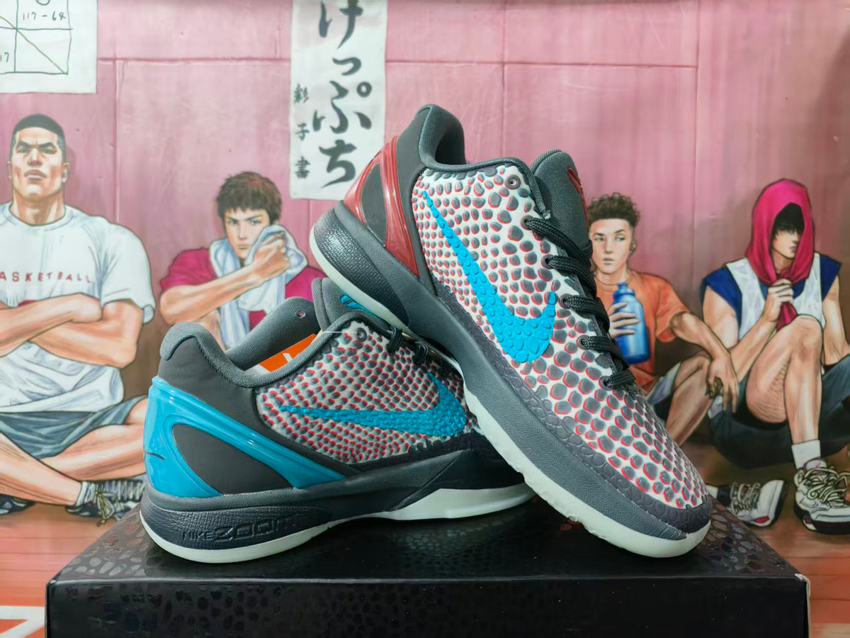 Pair of gray, black, blue, and red basketball sneakers displayed on a box, showing the patterned upper and blue side detailing.