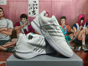 Angled view of white and silver Nike basketball shoes with turquoise details
