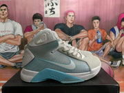 Side profile of a white and light blue Nike high-top basketball sneaker with a translucent blue side panel and blue outsole accent.