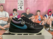 Side profile of a black sneaker with an iridescent multicolor side detail, black midsole, and light-colored outsole.