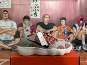 Side view of a gray Nike sneaker with a black Swoosh and red dragon graphic.