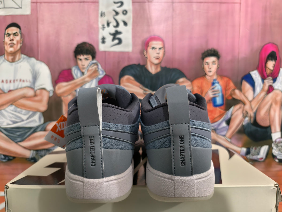 Rear view of smoke gray low-top sneakers showing Chapter One heel lettering, padded collars and light-colored textured soles.