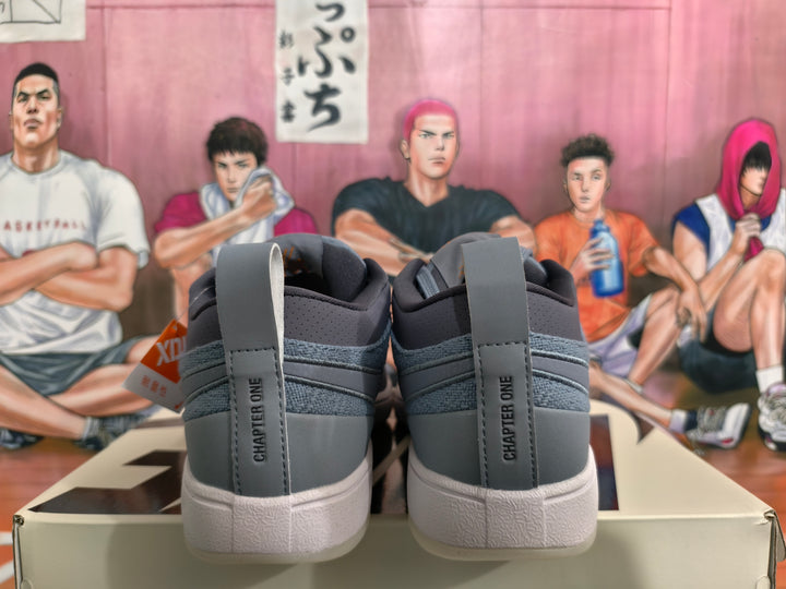 Rear view of smoke gray low-top sneakers showing Chapter One heel lettering, padded collars and light-colored textured soles.