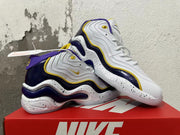 Pair of white Nike sneakers with purple and yellow accents, shown in a crossed side view.
