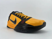 Angled front view of an orange-and-black low-top shoe from the opposite side.