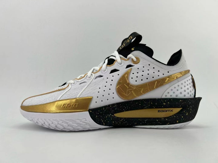 Side view of a white Nike basketball shoe with gold accents, a patterned Swoosh, and a black speckled midsole.