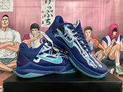 Pair of navy Nike Kobe basketball shoes with white and aqua graphics
