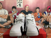 Front view of white and black Nike-branded sneakers with laces and hook-and-loop straps.