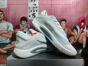 Angled view of paired white Nike basketball sneakers highlighting the side Swoosh, gray panels, heel branding, and outsole.