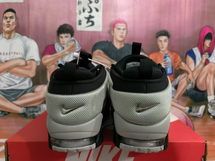 Rear view of black and grey Nike sneakers showing the padded collars, heel panels and visible sole window.
