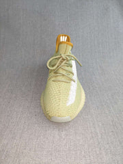 Top-front view of the green knit sneaker showing its lace arrangement, rounded toe, reflective side detail, and padded collar.