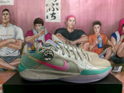 Side view of beige Nike basketball sneakers showing the patterned side panels, pink Swoosh, teal toe accent, and translucent outsole.