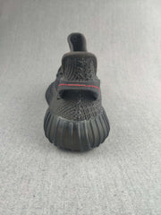 Rear view of a black sneaker showing the heel pull tab and ribbed outsole.