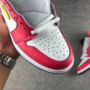 Close-up of the white perforated toe box, red toe overlay and white laces.