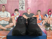 Front view of black running shoes with patterned laces and perforated-looking uppers.