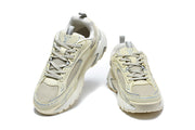 Pair of beige and grey Louis Vuitton sneakers shown from the front.