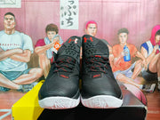 Front view of the black and red basketball sneakers showing the perforated tongue area, red-and-black laces, SC details, and patterned outsole.
