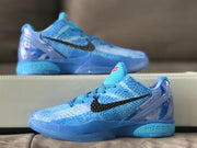 Close side profile of a blue basketball shoe with black branding and red tongue accents.