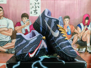Pair of blue and purple high-top basketball shoes with gold-tone laces and textured black outsoles, shown at an angle.