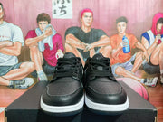 Front view showing the black lace-up sneakers, perforated toe panels and white midsoles.