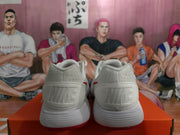 Rear view of white Nike sneakers showing embossed heel branding, white midsoles, and red outsole accents.