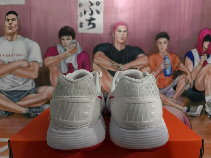Rear view of white Nike sneakers showing embossed heel branding, white midsoles, and red outsole accents.