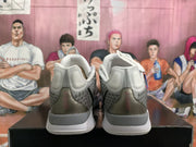 Rear view showing the padded heels, gray upper panels, pink accents, and white midsoles.