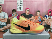 Side view of a lime-yellow and orange Nike basketball sneaker with a black Swoosh.