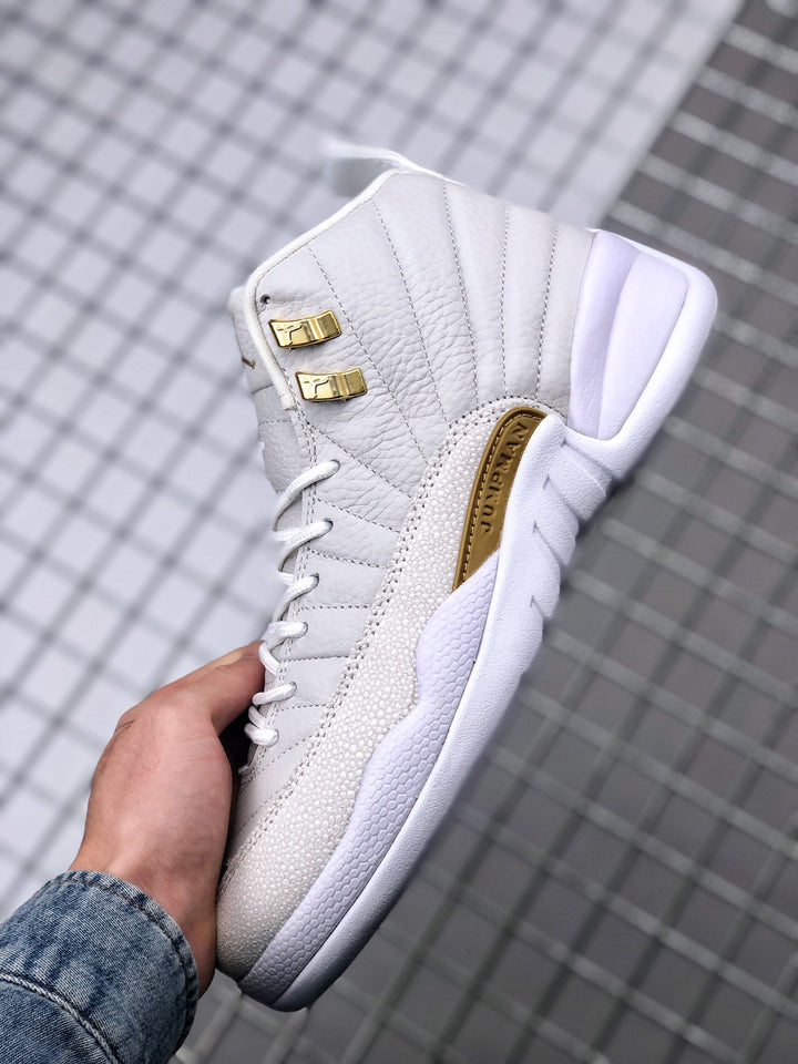 Close-up side view of a white high-top Jordan sneaker with gold-tone hardware and a textured side overlay.