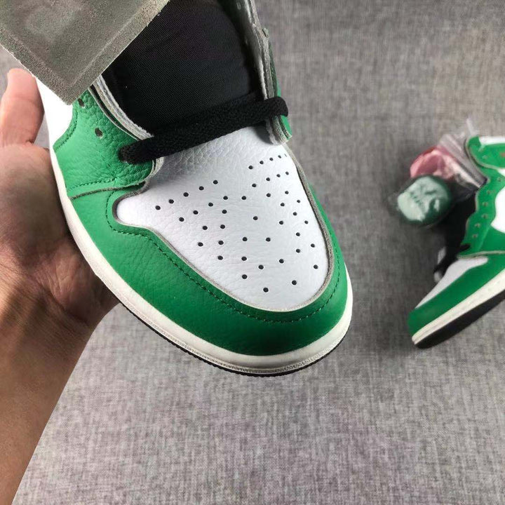 Close-up of the green and white perforated toe box with black laces.