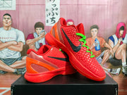 Angled view of the red-orange shoes, showing the black swoosh, green laces, textured upper, and heel detail.