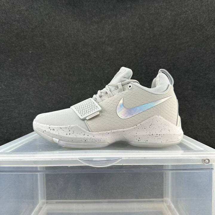 Gray and white Nike basketball shoe with a forefoot strap, iridescent-looking Swoosh, and speckled midsole.