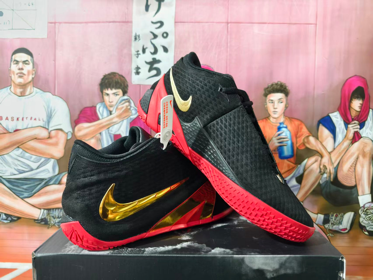 Pair of black basketball shoes with gold side accents and red soles, shown at an angle.