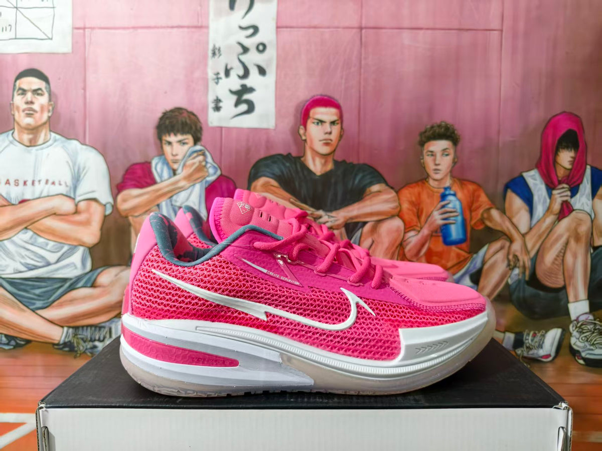 Pink Nike basketball shoes shown from the side with white Swoosh details