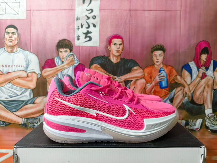 Pink Nike basketball shoes shown from the side with white Swoosh details
