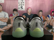 Rear view of the pair showing heel branding, silver uppers, and green outsole areas.