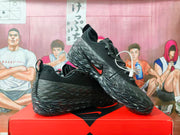 Side view of black Nike sneakers with angular textured panels, patterned laces, and a red accent.