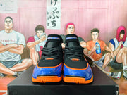 Front view of black Nike Air Huarache 2K4 shoes with blue and orange toe accents