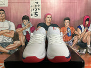 Front view of white Nike basketball shoes with red tongue logos and red outsole accents.