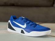 Front three-quarter view showing the blue upper, lace system, white swoosh, and layered white outsole.