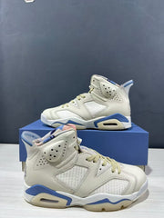 Angled side view of the pair highlighting the cream upper, blue midsole sections, and textured overlays.