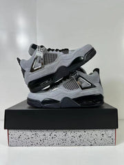 Gray and black Air Jordan 4 Retro sneakers stacked on a speckled shoebox.