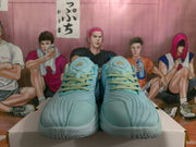 Front view of pale aqua basketball shoes with contrasting laces and tongue logos