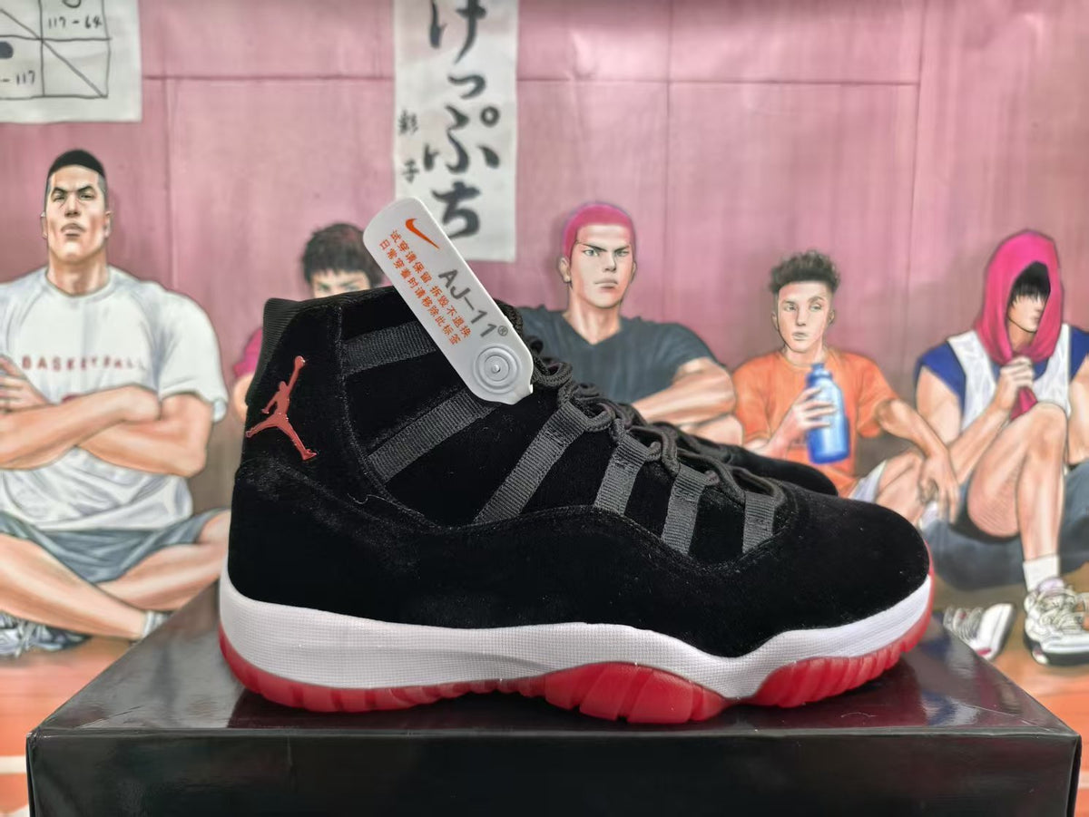 Side view of a black high-top basketball sneaker with red branding, a white midsole, and a translucent red outsole on a black box.