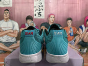 Rear view of teal basketball sneakers with black collars, red and white heel lettering, and white midsoles.