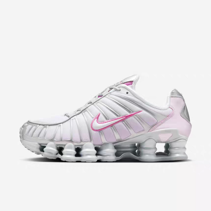 Side view of white Nike Shox TL-style sneakers with pink Swoosh accents and a columned sole.